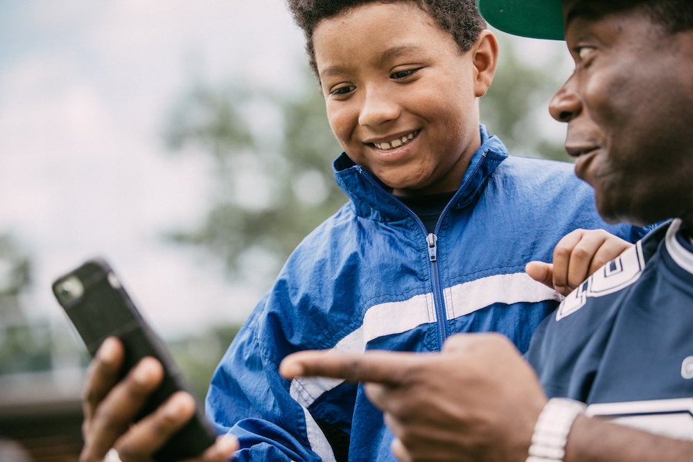 Fans holding a smartphone chatting about features